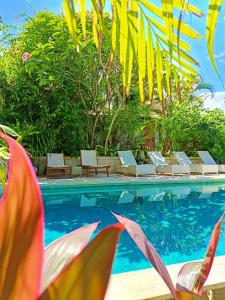 a swimming pool with lounge chairs next to a resort at Bale Sampan Boutique Bungalows in Gili Trawangan