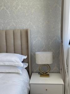 Un dormitorio con una cama y una lámpara en una mesita de noche. en Desert Pearl, en Windhoek 27 fotos más