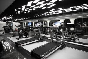 a gym with treadmills and ellipticals in a room at Xi'an MC City Courtyard Hotel - A st andalone hotel by the city wall - Close to the bell tower and yongning gate - Designed in song dynasty aesthetic style - It features private courtyard and garden rooms - Integrating the historical culture of Xi'an in Xi'an