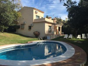a swimming pool in front of a house at Villas Marbella in Marbella