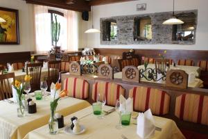 un restaurante con mesas y sillas con flores. en Hotel Restaurant Schweizerhaus en Klagenfurt
