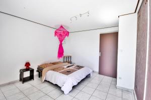 a bedroom with a pink kite hanging from the ceiling at Belle villa, accrochée à la montagne in La Possession +32 photos
