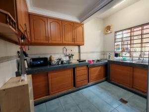 a large kitchen with wooden cabinets and a window at 4 Bedrooms 4 Bathrooms 10Pax Comfy Sleeps Landed Spacious House in Seri Kembangan