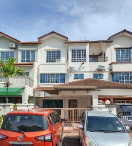 two cars parked in front of a building at 4 Bedrooms 4 Bathrooms 10Pax Comfy Sleeps Landed Spacious House in Seri Kembangan