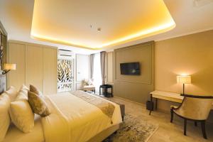 a bedroom with a bed and a desk and a television at De Bijou Boutique Hotel Yogyakarta in Demangan
