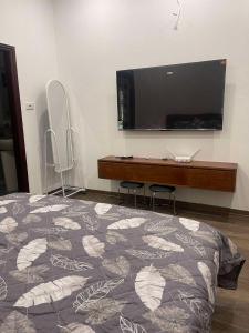 a bedroom with a bed and a tv on the wall at HnH Homestay 2 in Hanoi +10 photos