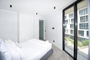a white bedroom with a bed and a large window at Thango Res Ellipse Waterfall. in Midrand +21 photos