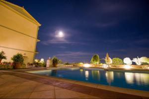 a swimming pool at night with the moon in the sky at Eagle's Nest in Lourdhata