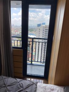 a bedroom with a view of a city from a window at Makati Ayala luxury Stylish Uncle Sam condo Gym Swim Park 300 Mb 2641 in Manila