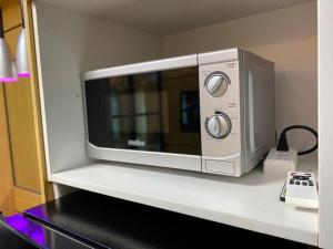 a microwave sitting on top of a counter at Makati Ayala luxury Stylish Uncle Sam condo Gym Swim Park 300 Mb 2641 in Manila