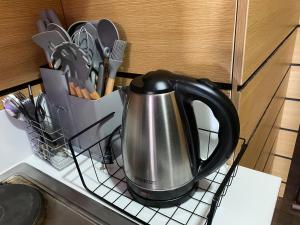 a tea kettle is sitting on a drying rack at Makati Ayala luxury Stylish Uncle Sam condo Gym Swim Park 300 Mb 2641 in Manila