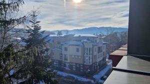 a view of a building with snow on the ground at Concrete comfort in Samokov