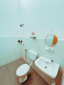 a bathroom with a toilet and a sink and a mirror at Fallem's Homestay Melaka I 4 ROOMS I FULLY AIRCOND I 9 PAX I FREE WIFI I NETFLIX I INTEX POOL in Malacca +19 photos