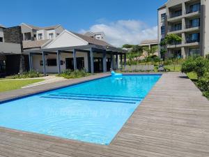 a swimming pool in front of a building at Apartment 276 Ballito Village in Ballito