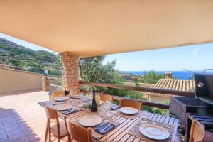 Una mesa en un balcón con vista al mar. en Deluxe Villa Sardinia Holidays, en Costa Paradiso