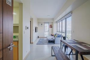 a dining room and living room with a table at Luxury Corner Suite 1 Bedroom plus Den Top Floor Birds Eye View Spacious 668 square Feet in Iloilo City +106 photos