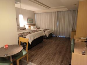 een hotelkamer met twee bedden en een tafel bij RARIDADE!!! - Flat Particular de Alto Padrão - Limpeza Diária Gratuita - Excelente Atendimento - Ótimo Preço - Cama King Size - Dentro do Hotel Lets Idea in Brasilia