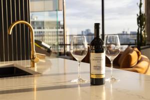 a bottle of wine sitting on a counter with two wine glasses at Luxury Large 2 Bedroom Apartment Panoramic City Views! in Brisbane +23 photos