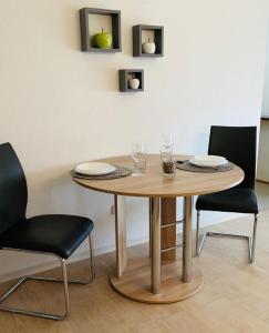 a wooden table with two chairs and a table with glasses at Glückseligkeit NEU RENOVIERT in Bad Bergzabern +1 photo