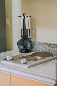 a kitchen counter with a stove with some utensils at Luxury Corner Suite 1 Bedroom plus Den Top Floor Birds Eye View Spacious 668 square Feet in Iloilo City