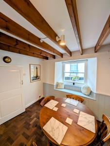 a dining room with a wooden table and chairs at Cosy Beach Cottage - Cawsand in Cawsand