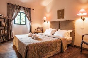 ein Schlafzimmer mit einem Bett mit zwei Handtüchern darauf in der Unterkunft Les anciennes écuries, belle villa pour 12 personnes au coeur d'un vignoble avec piscine in Sartène