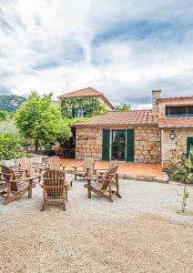 eine Gruppe von Stühlen und Tischen vor einem Haus in der Unterkunft Les anciennes écuries, belle villa pour 12 personnes au coeur d'un vignoble avec piscine in Sartène