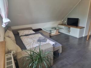 a living room with a couch and a table at Kleine Auszeit im 1 OG in Heede
