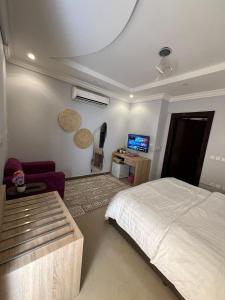 a bedroom with a bed and a couch and a tv at Smart Entry Room Grnada in Riyadh