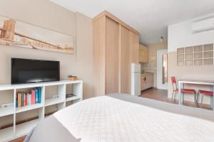 ein Schlafzimmer mit Bett und eine Küche mit Tisch in der Unterkunft Acogedor estudio en Pedregalejo junto al mar in Málaga