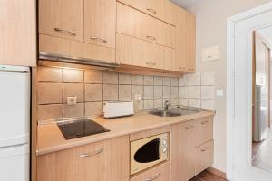 eine Küche mit Holzschränken und einer Spüle in der Unterkunft Acogedor estudio en Pedregalejo junto al mar in Málaga