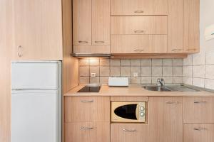 eine Küche mit Spüle und Mikrowelle in der Unterkunft Acogedor estudio en Pedregalejo junto al mar in Málaga