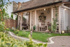 ein Haus mit Wintergarten und einem Tisch im Garten in der Unterkunft Villa V in Braşov