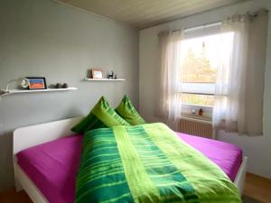 1 dormitorio con 1 cama con sábanas coloridas y ventana en Ferienhaus Waldblick, en Waltershausen