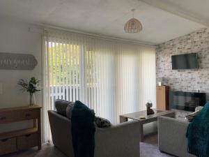 a living room with a couch and a tv at Holiday Cabin Sleeps 5 Glan Gwna Holiday Park in Caernarfon