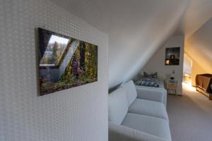 a living room with a couch and a painting on the wall at KIosterlinchen in Walkenried