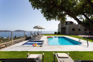 basen z krzesłami i parasolem w obiekcie Elounda Olea Villas And Apartments w Elundzie
