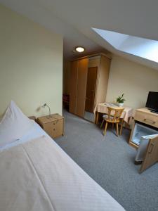 a hotel room with a bed and a table and chairs at Pension Dornröschen in Bad Füssing