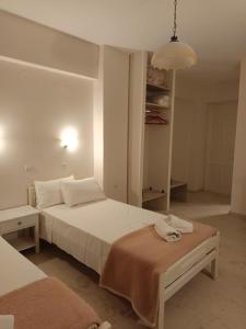 a white bedroom with a bed and a table at Molyvos Stars Apartments in Mythimna +7 photos
