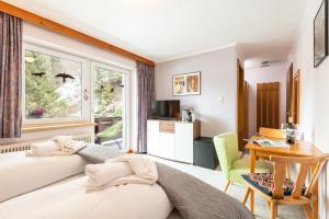 una camera da letto con un letto, una scrivania e una finestra di Apartmenthaus Beaverwier a Biberwier