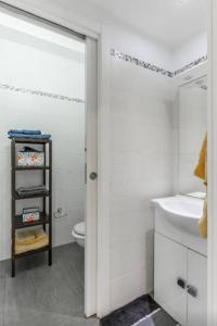a white bathroom with a sink and a toilet at Il Paesino Loft in Licodia Eubea