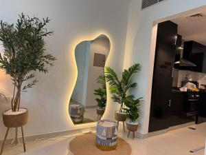 a room with three potted plants and a mirror at ASHRI HH, Bohemian Style Condo in Downtown in Dubai