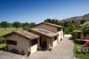 a house with a tile roof and a courtyard at appartamenti vacanza antica mattonata in Stazione di Assisi