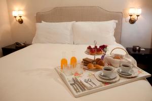 - un plateau de nourriture sur un lit avec boissons et collations dans l'établissement Quinta Miraflores Boutique Hotel, à Lima