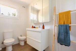 a white bathroom with a toilet and a sink at MASIA CENTENARIA EN SITGES in Sitges
