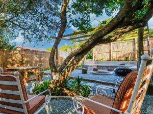 une terrasse avec 2 chaises, une table et un arbre dans l'établissement Ginger Lake Wilderness, à Wilderness