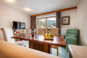una sala da pranzo con tavolo e cesto di frutta di Apartmenthaus Beaverwier a Biberwier