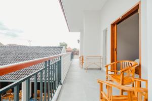 a balcony with wooden chairs and a window at Turtle Shelter Guest House in Sanur +43 photos