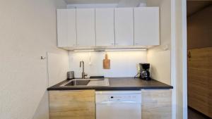 una cucina con mobili bianchi e un lavandino di Résidence Verseau - Appartement lumineux et spacieux · Centre station · avec cabine et Balcon MAE-7781 a Magland Altre 10 foto