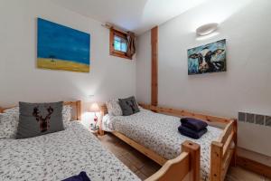 um quarto com duas camas e uma janela em Résidence Bergerie Des 3 Vallees F - Appartement 4 pièces 6 personnes situé dans le charmant village des allues MAE-4991 em Les Allues